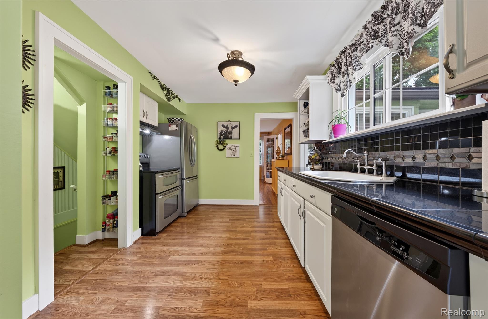 3841 Covert Road Waterford, MI 48328 - Photo 11 of 87 Kitchen featuring wood-finish flooring, white cabinetry, dark countertops, and stainless steel appliances