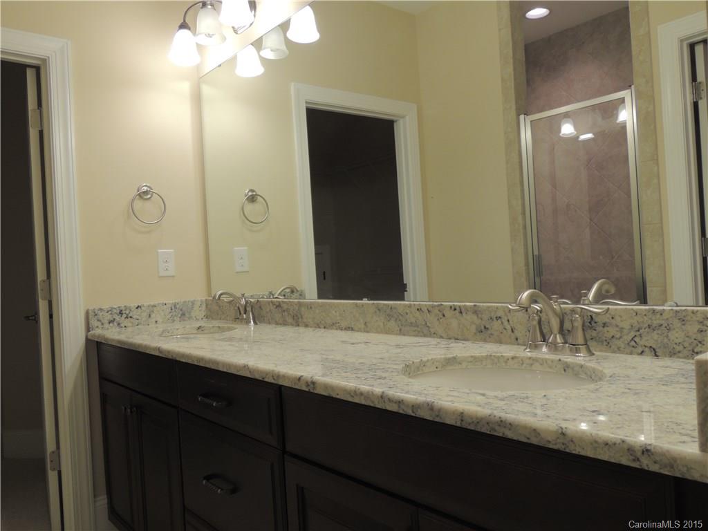 925 Ospre Lane, Unit 162 Fort Mill, SC 29708 - Photo 14 of 22 a bathroom with a granite countertop sink a large mirror and a shower
