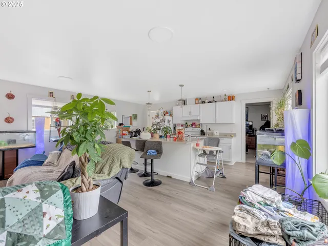 a living room with furniture and a dining table with wooden floor