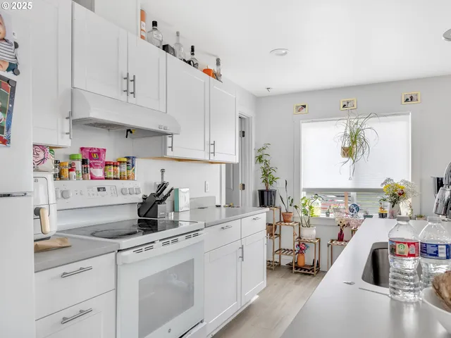 a kitchen with cabinets a sink and white appliances