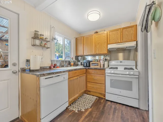 a kitchen with a sink cabinets stainless steel appliances and a window