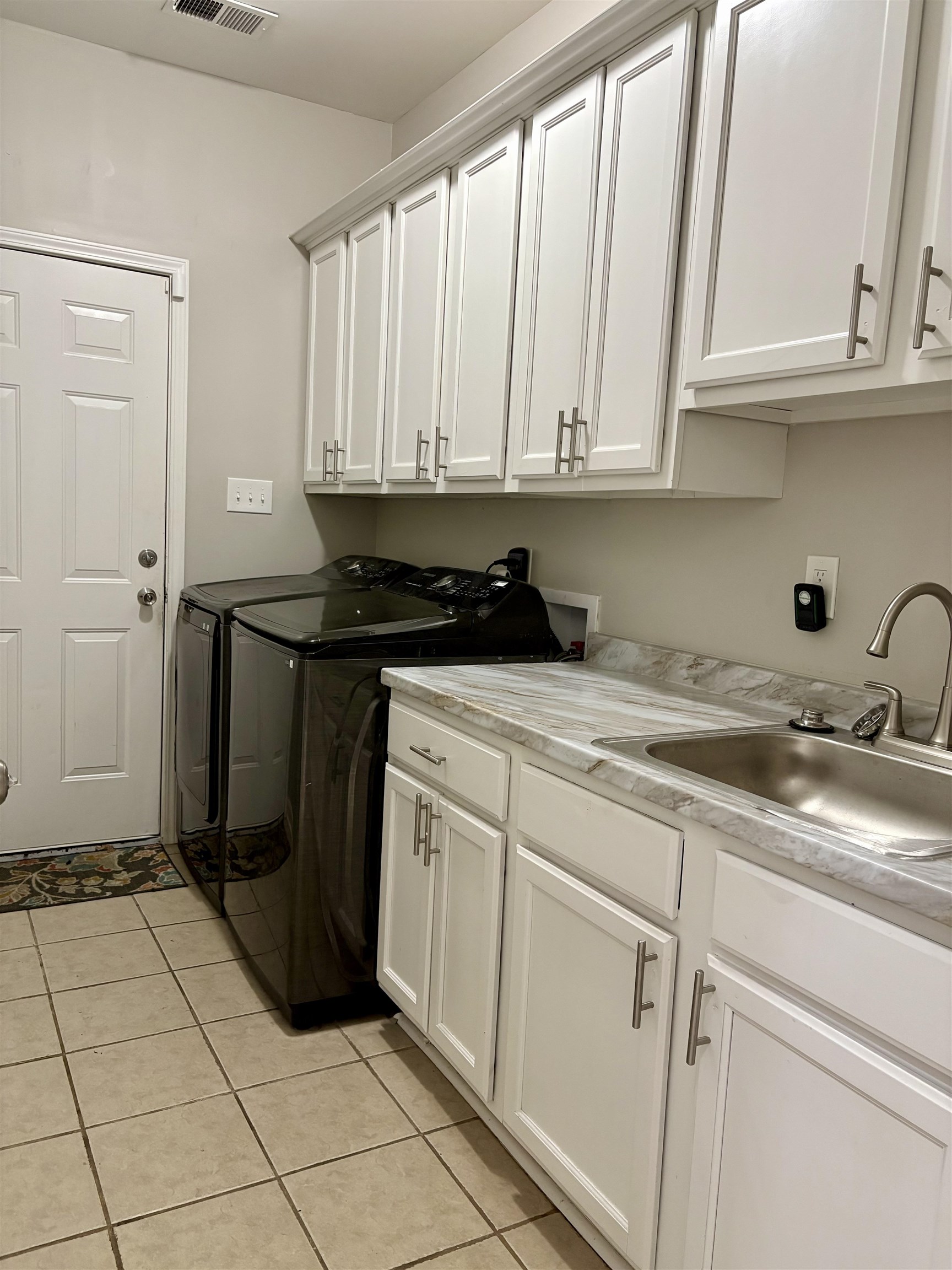 9107 Raspberry Lane Cordova, TN 38016 - Photo 15 of 26 Laundry room featuring cabinet space, light tile patterned floors, and washer and clothes dryer