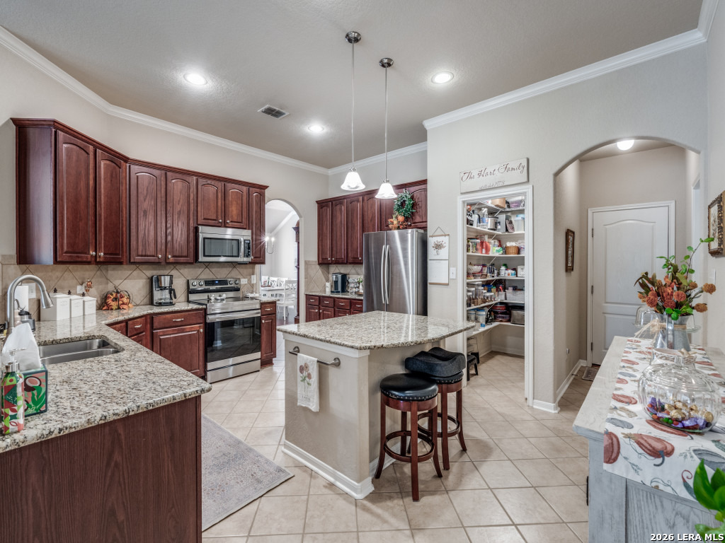 6050 Covers Schertz, TX 78108 - Photo 10 of 25 a kitchen with stainless steel appliances granite countertop a stove top oven a sink dishwasher and a refrigerator with wooden cabinets