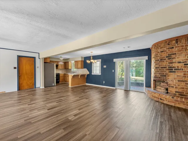 a view of empty room with wooden floor and fireplace