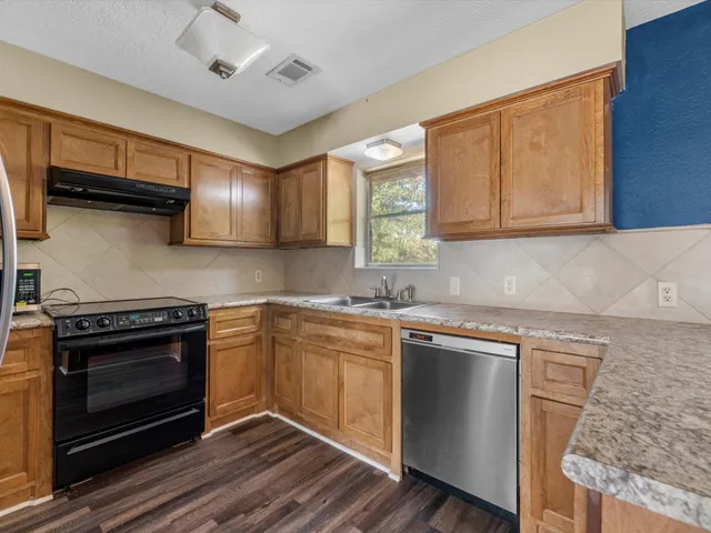 a kitchen with stainless steel appliances granite countertop a stove and a sink