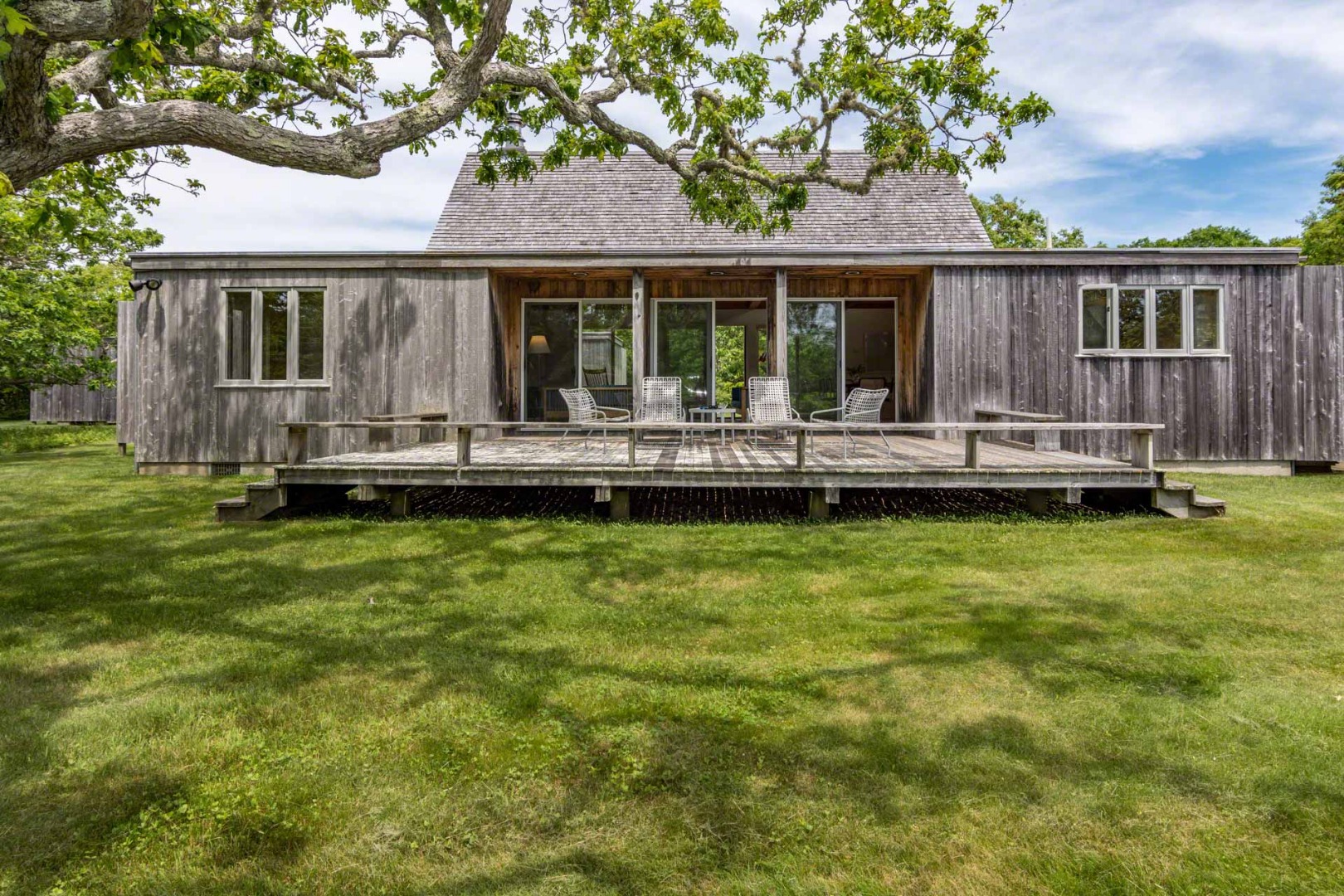 7 Black Point Road Chilmark, MA 02535 - Photo 2 of 44 a front view of a house with a yard table and chairs