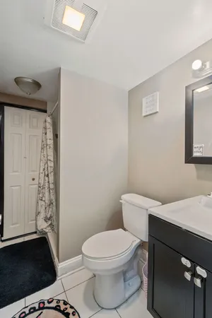 a white toilet sitting next to a bathroom sink and vanity