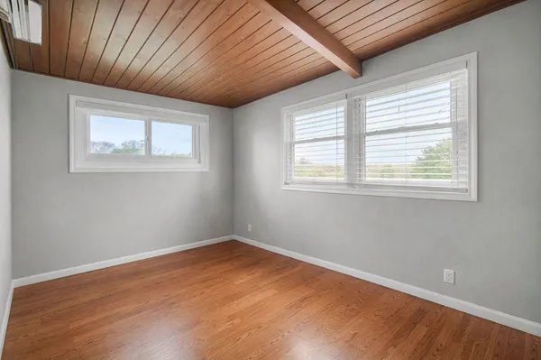 a view of empty room with wooden floor