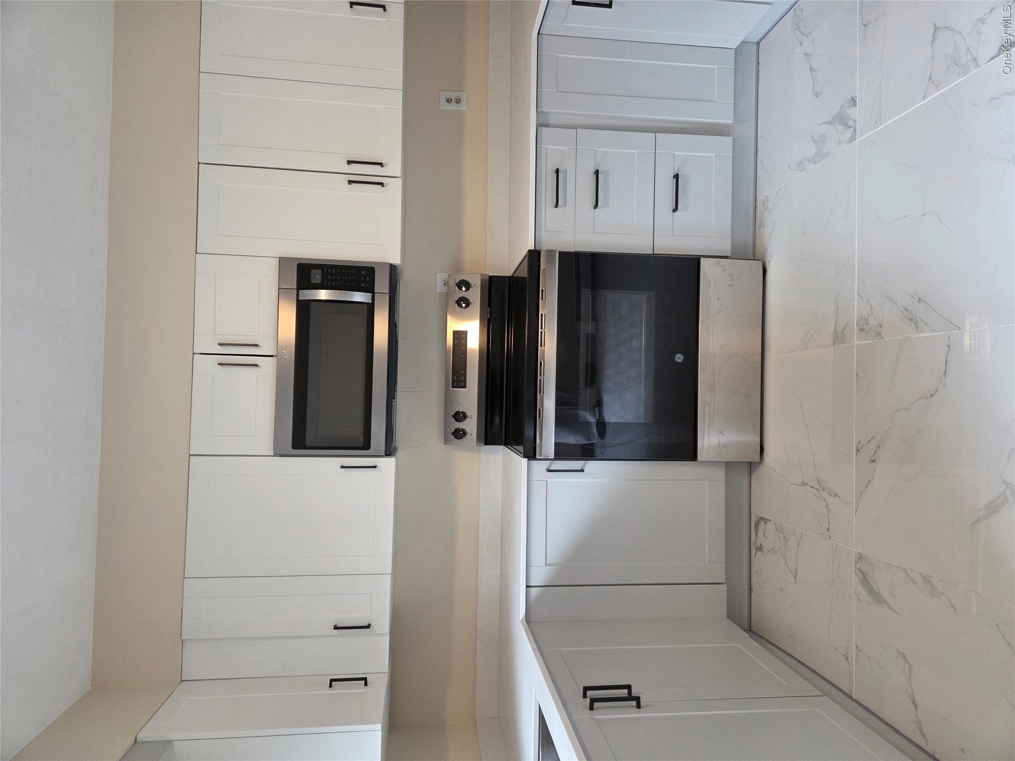 193 Overhill Road, Unit R Stormville, NY 12582 - Photo 4 of 10 a kitchen with white cabinets and appliances