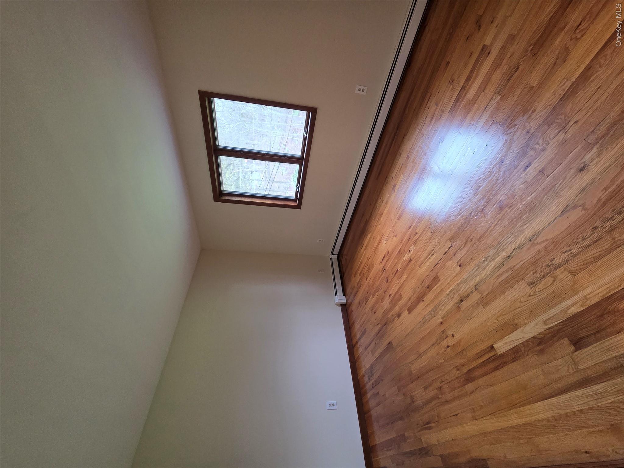 193 Overhill Road, Unit R Stormville, NY 12582 - Photo 5 of 10 an empty room with wooden floor and windows