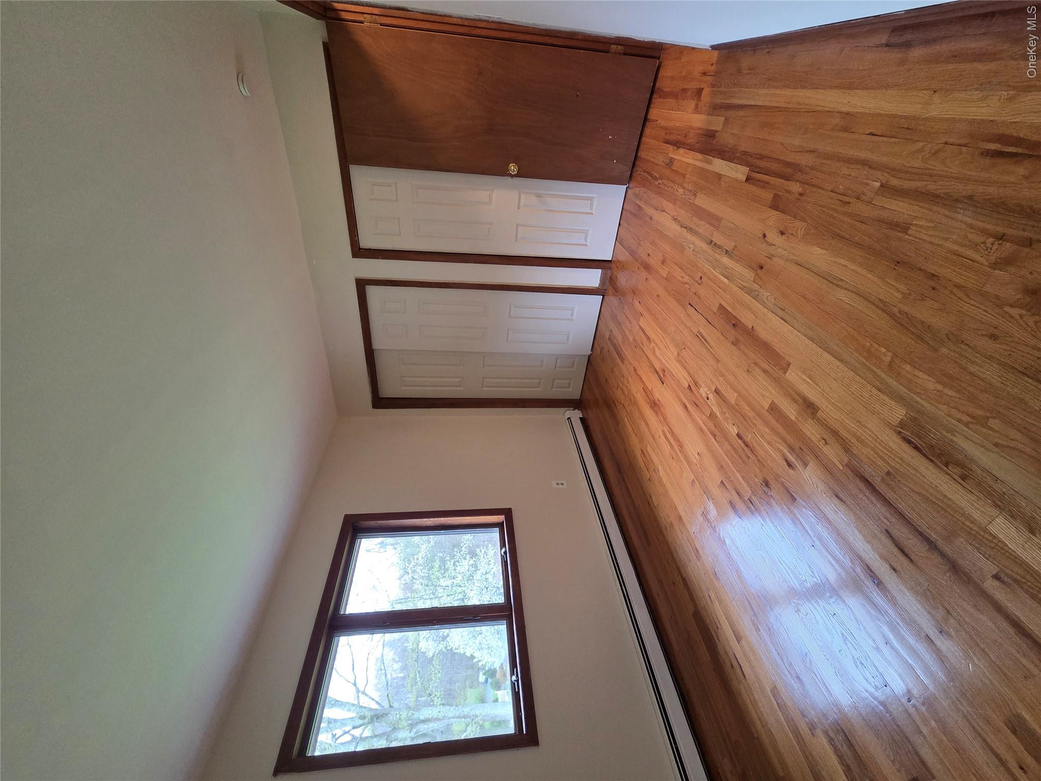 193 Overhill Road, Unit R Stormville, NY 12582 - Photo 8 of 10 a view of an empty room with wooden floor and a window