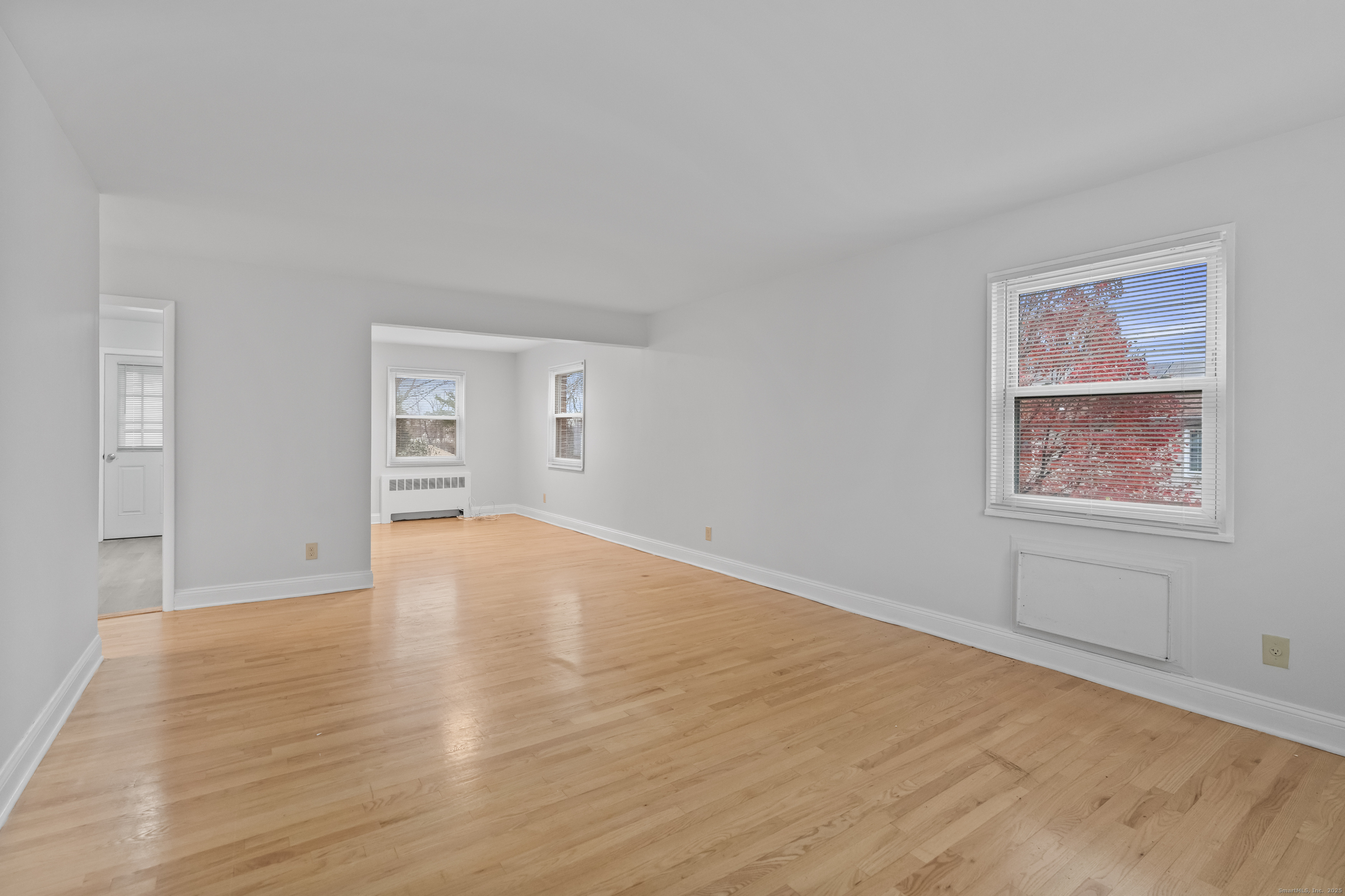 66 Blachley Road, Unit C Stamford, CT 06902 - Photo 5 of 26 an empty room with wooden floor and windows