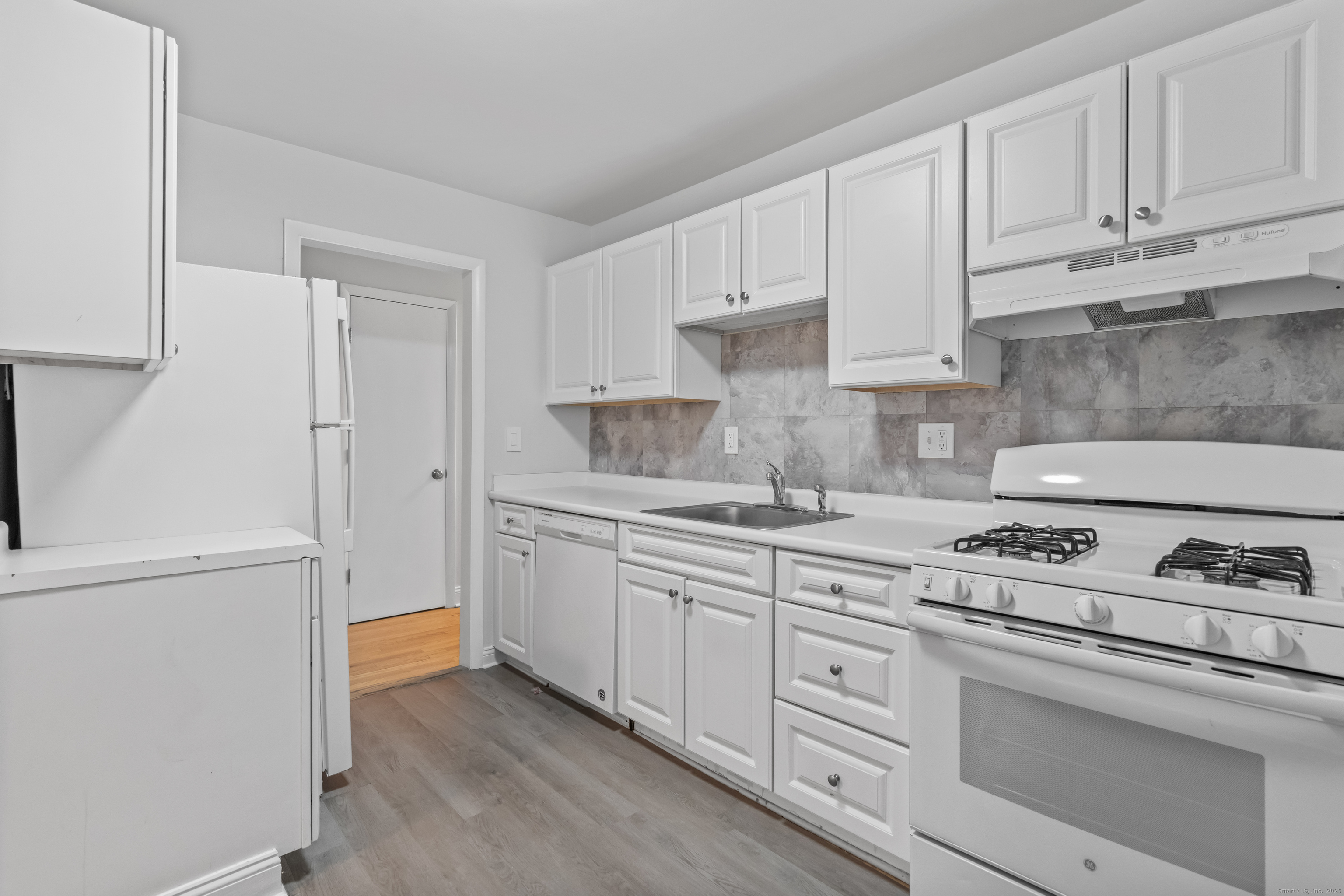66 Blachley Road, Unit C Stamford, CT 06902 - Photo 10 of 26 a kitchen with granite countertop white cabinets and white appliances