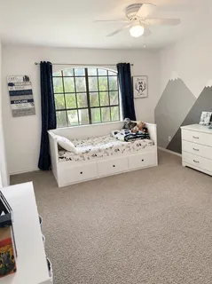 a bedroom with a bed and a large window