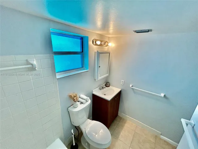 a bathroom with a toilet a sink and mirror