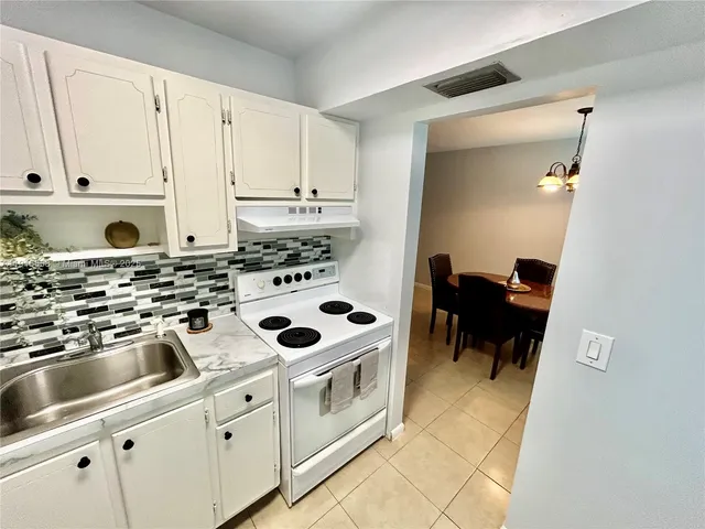 a kitchen with stainless steel appliances a sink a stove a microwave and a refrigerator