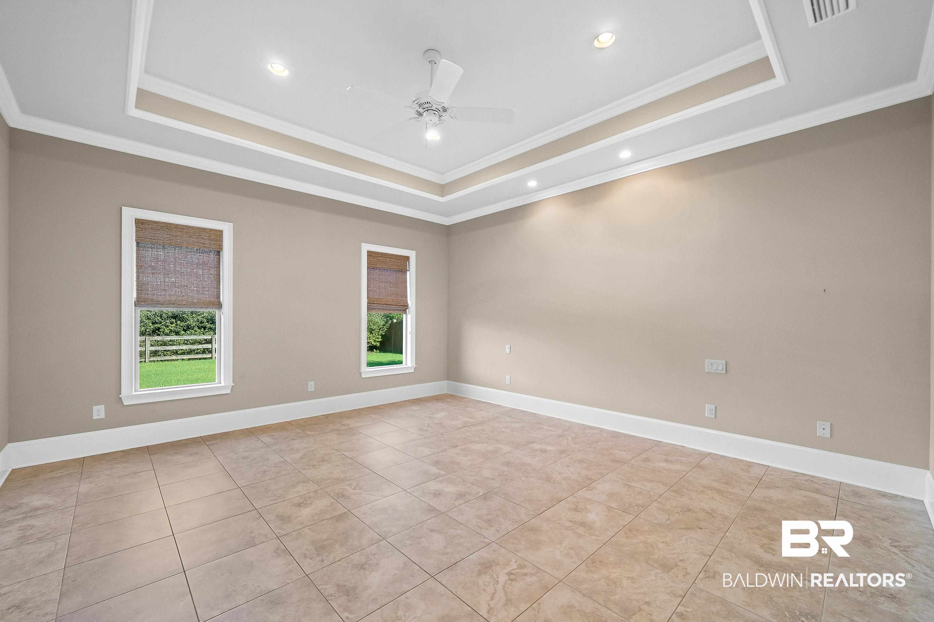 17663 Burwick Loop Fairhope, AL 36532 - Photo 25 of 41 Spare room with a tray ceiling, ceiling fan, light tile patterned floors, and crown molding