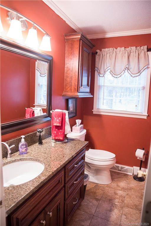 101 Sycamore Road, Unit 209 Salisbury, NC 28147 - Photo 17 of 33 a bathroom with a granite countertop toilet sink and mirror