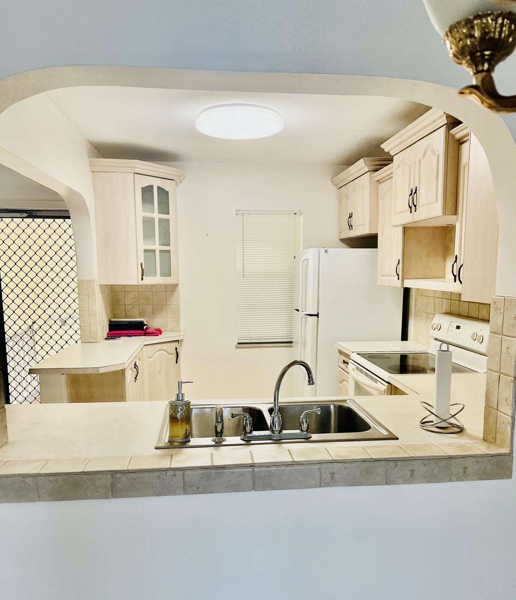 a kitchen with a sink a stove and white cabinets