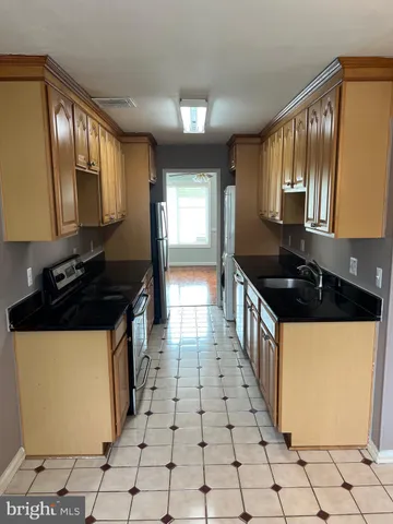 a kitchen with granite countertop a stove a sink and a microwave