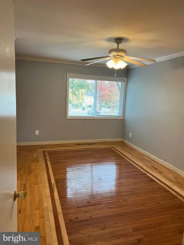 a view of a room with wooden floor chandelier and a window