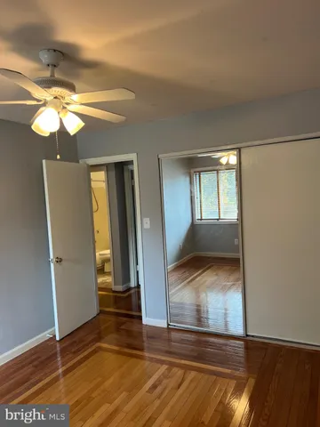 a view of a livingroom with wooden floor and a ceiling fan