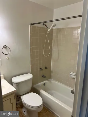 a white toilet sitting next to a bath tub and a shower