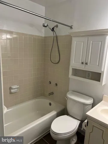 a white toilet sitting next to a bath tub and a shower