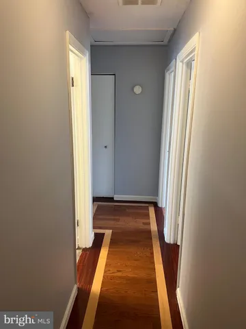 a view of a hallway with wooden floor and a window