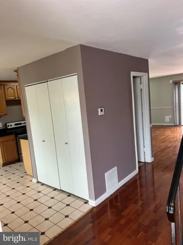 a view of a hallway with wooden floor and stairs