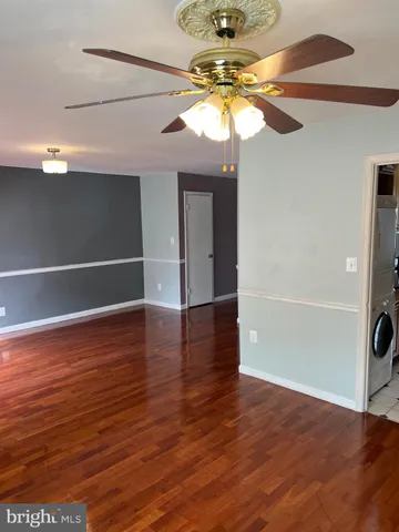 a view of a livingroom with a chandelier and wooden floor