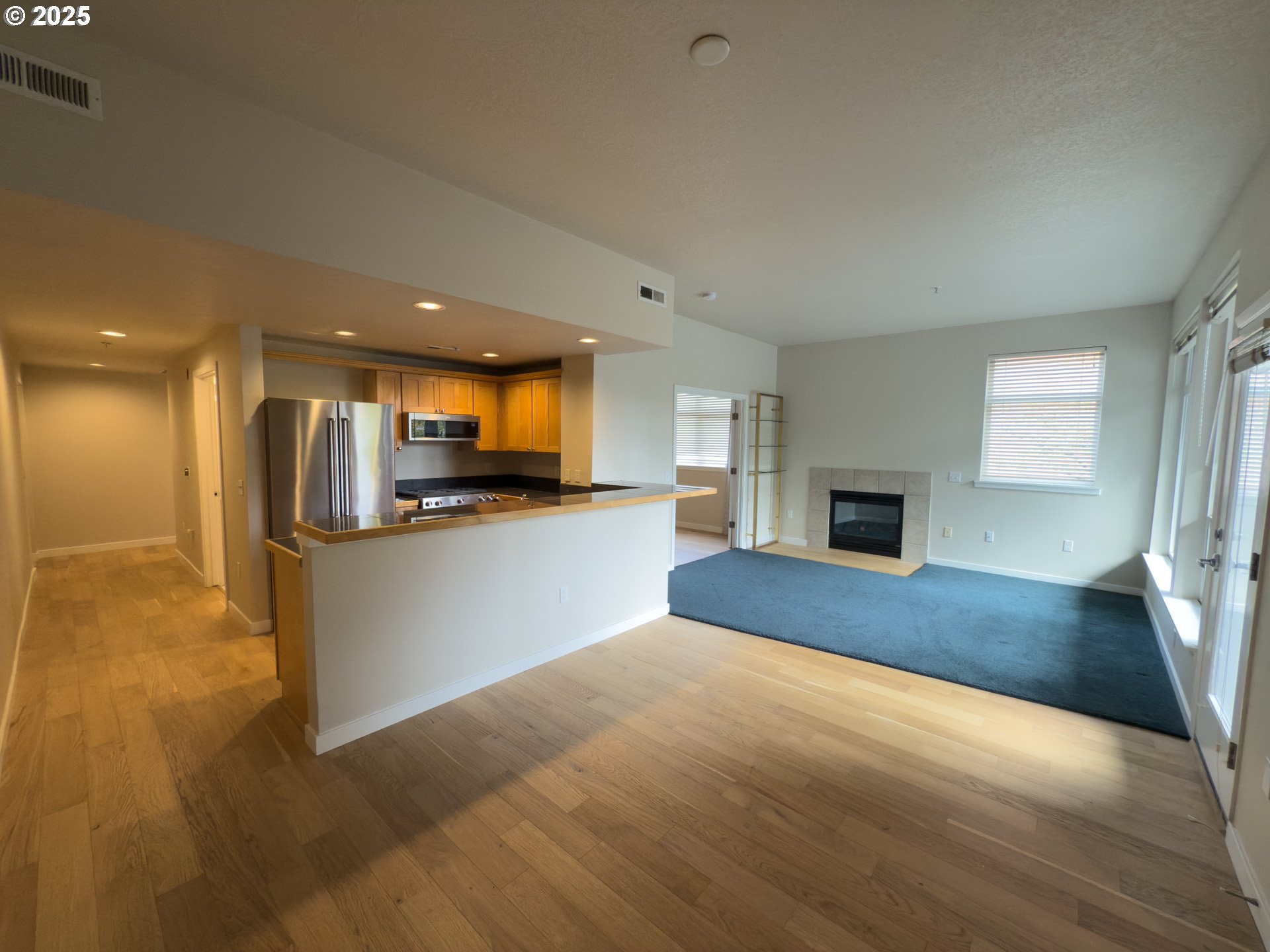 2327 Northwest Northrup Street, Unit 8 Portland, OR 97210 - Photo 3 of 33 a view of kitchen with kitchen island a sink wooden floor and a refrigerator