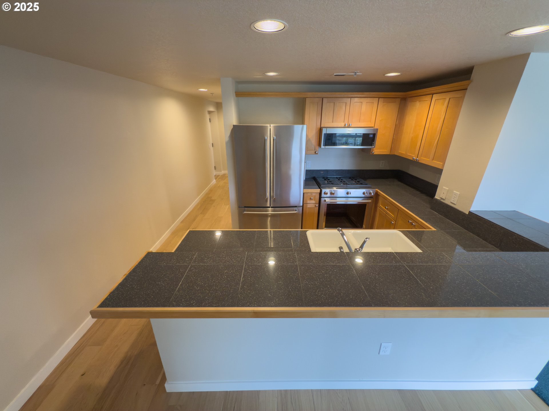 2327 Northwest Northrup Street, Unit 8 Portland, OR 97210 - Photo 7 of 33 a kitchen with kitchen island a counter top space cabinets and stainless steel appliances