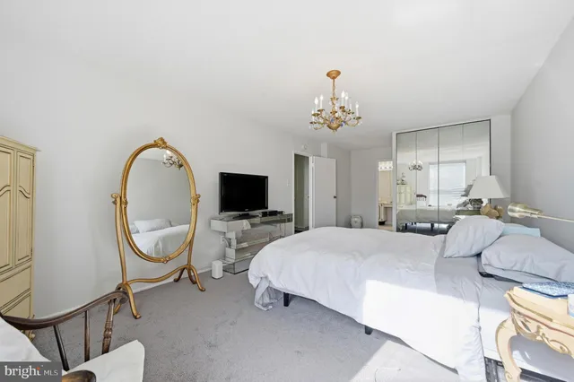 a spacious bedroom with a bed and a chandelier