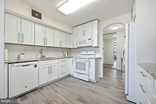 a kitchen with a chair and white cabinets