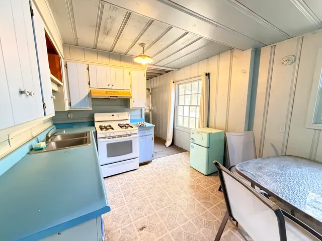 a kitchen with a stove a sink and a refrigerator