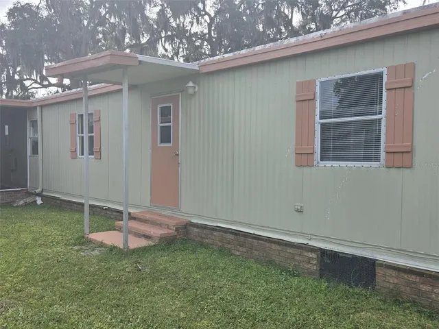 a backyard of a house with table and chairs