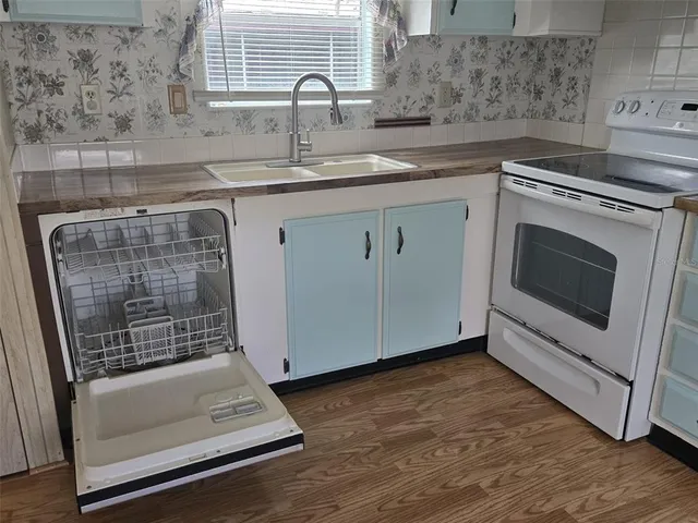 a kitchen with granite countertop a sink a stove and cabinets