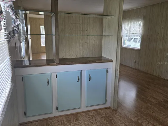 a kitchen with a sink and wooden floor