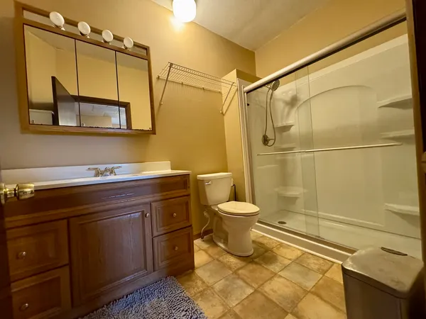 a bathroom with a granite countertop sink toilet and shower