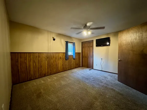 a view of an empty room with a ceiling fan