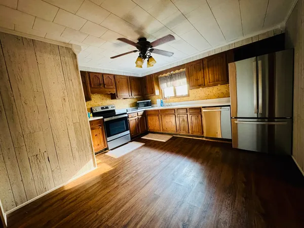 a kitchen with granite countertop stainless steel appliances a stove cabinets and wooden floor