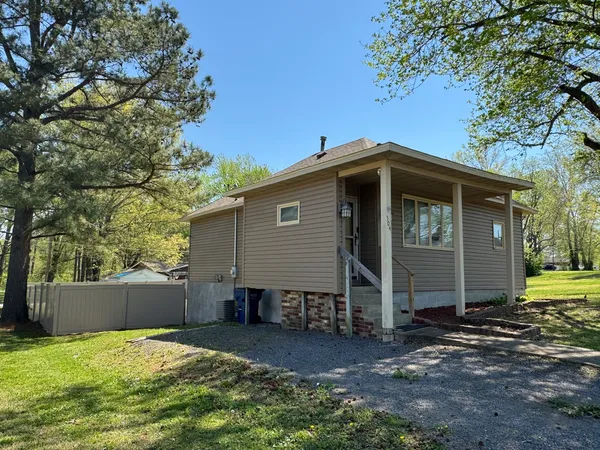 a view of a house with backyard and trees