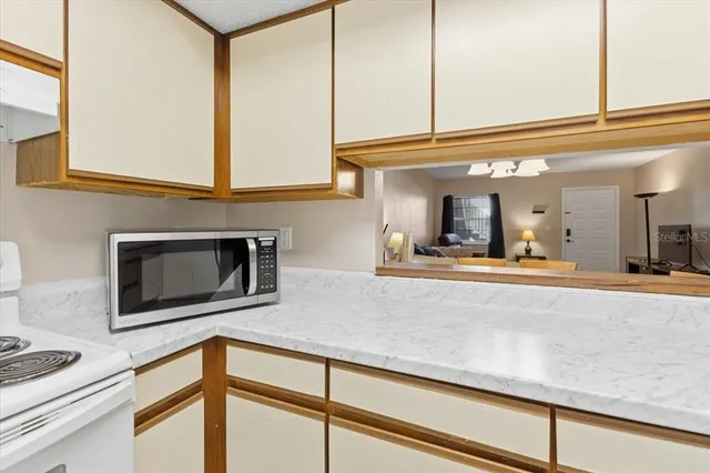 a living room with stainless steel appliances kitchen island granite countertop a sink and cabinets
