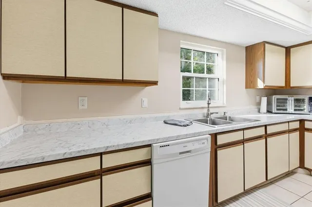 a kitchen with granite countertop cabinets sink and window