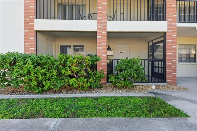 a front view of a house with a yard and potted plants