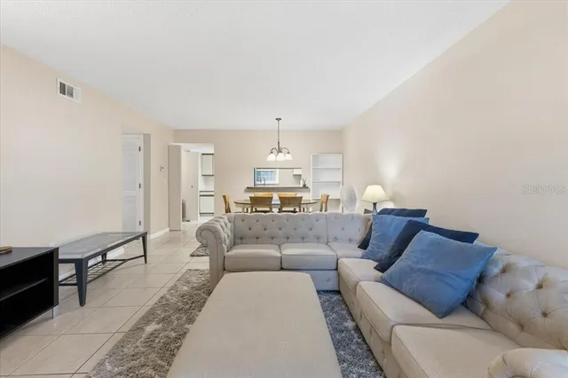 a living room with furniture and a chandelier
