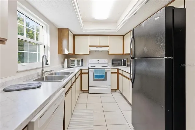 a kitchen with a refrigerator sink and cabinets