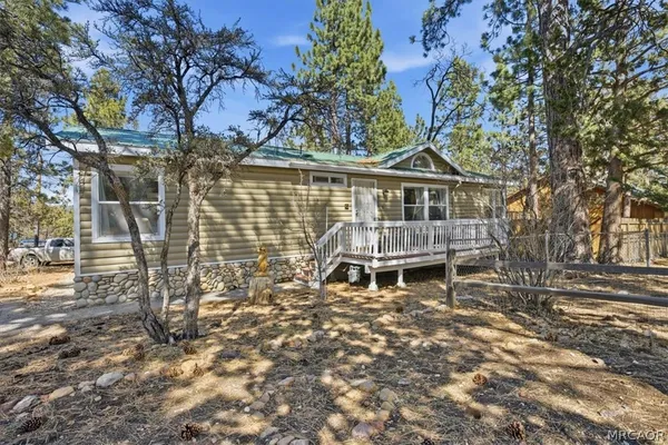 a view of a house with a large tree and a yard