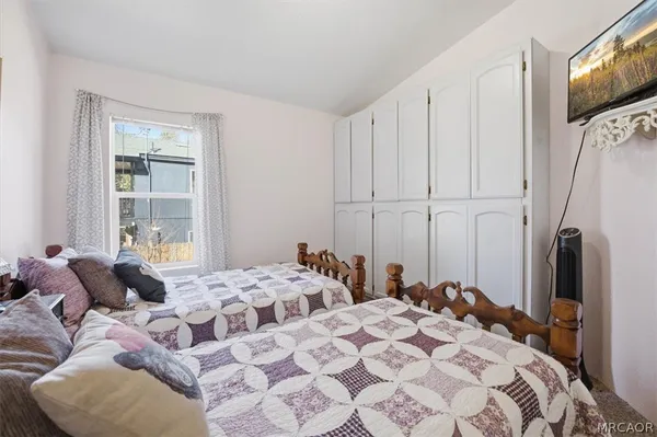 a bedroom with a bed a table and painting on the wall